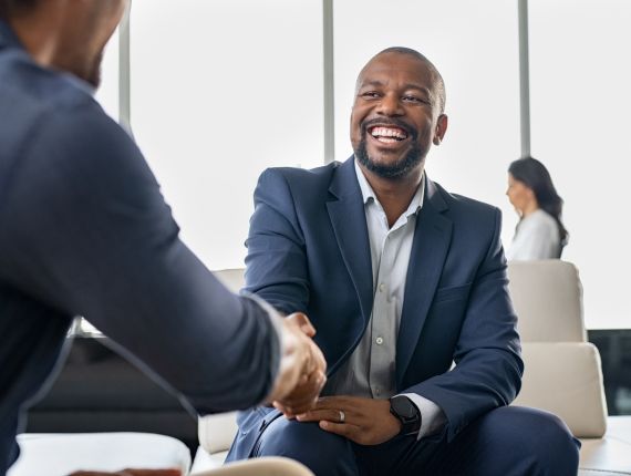 Business owner and investor shaking hands in agreement.
